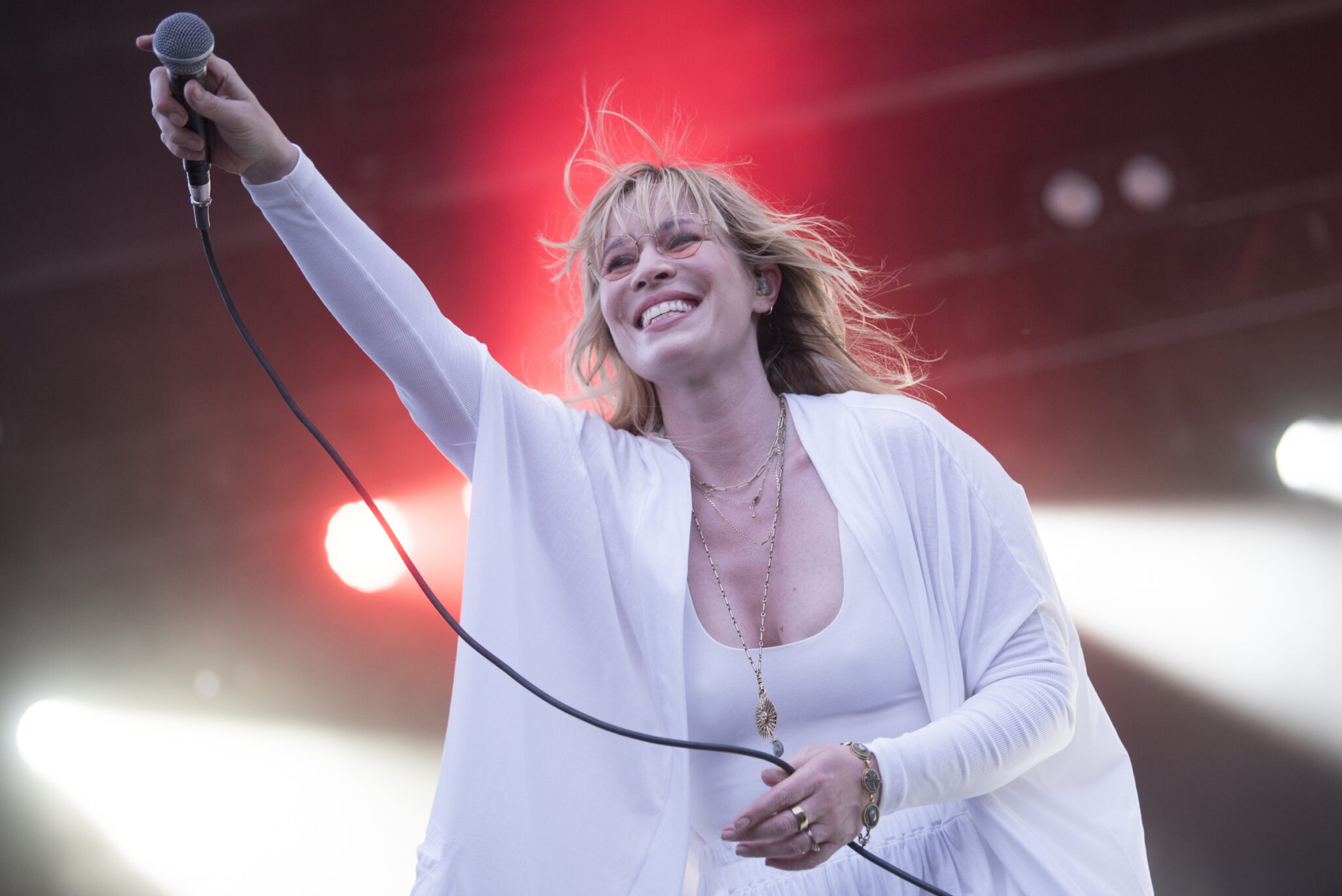 Natasha Bedingfield holds her microphone out to the crowd.